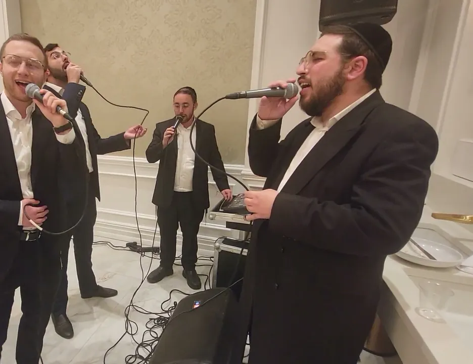 Moshe Ney singing with other vocalists at a live performance